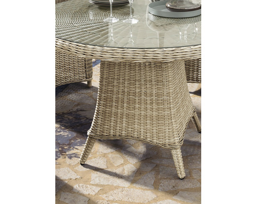 Vue détaillée d''une table de jardin ronde avec plateau en verre et structure en rotin