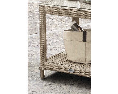 Vue détaillée d''une table en rotin avec plateau en verre et étagère avec porte-revues