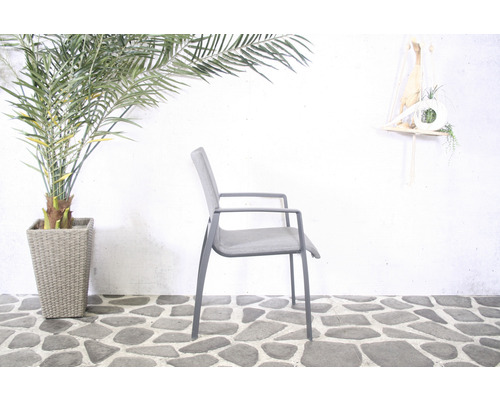 Scène de jardin avec un fauteuil gris, une plante d''intérieur en pot et décoration