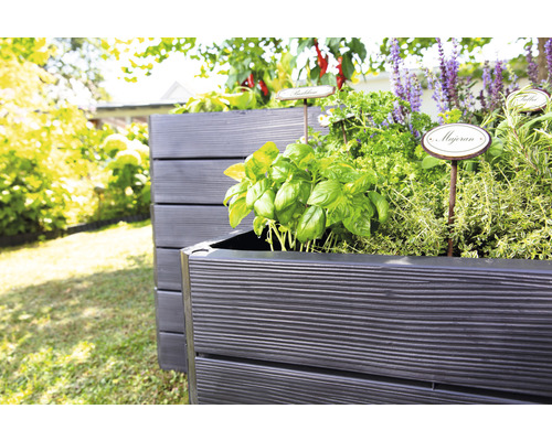 Zwei Hochbeete aus Holz im Garten bepflanzt mit verschiedenen Kräutern und Gemüsesorten.