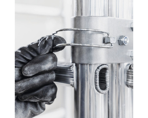 Detailaufnahme einer Hand mit Arbeitshandschuh, die eine Leitersicherung anbringt