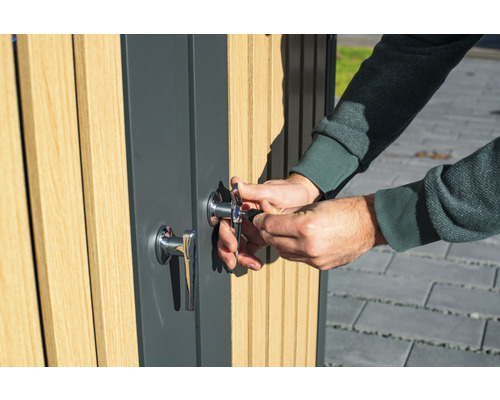 Eine Person schließt eine Tür mit Schloss und Schlüssel auf