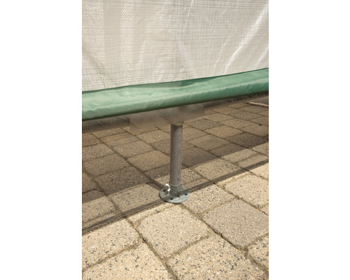 Detailansicht eines Gewächshausfußes auf einem gepflasterten Untergrund