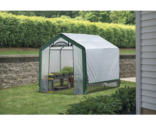 Gewächshaus mit Regalen im Garten