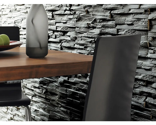 Nahaufnahme von einer Wandverkleidung aus Steinimitat hinter einem Esstisch mit Stühlen