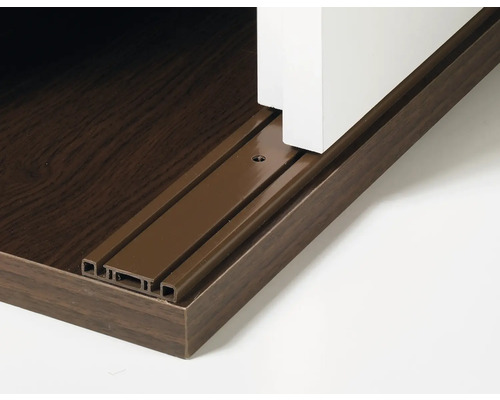 Detailaufnahme einer Schiebetürführung aus Metall an einem Möbelstück