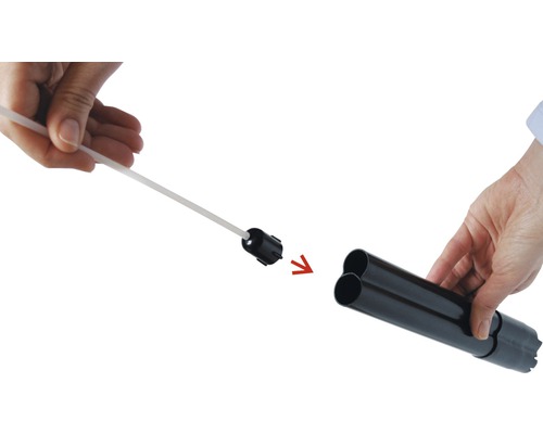 Image d''une personne insérant une brosse de nettoyage dans un tuyau d''évacuation