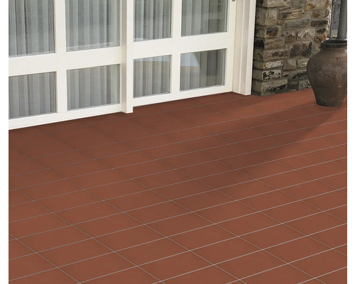 Verlegte Bodenfliesen auf einer Terrasse mit Tür und Topf.