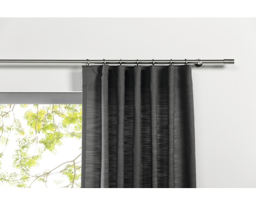 Rideau à œillets sur une tringle à rideaux devant une fenêtre