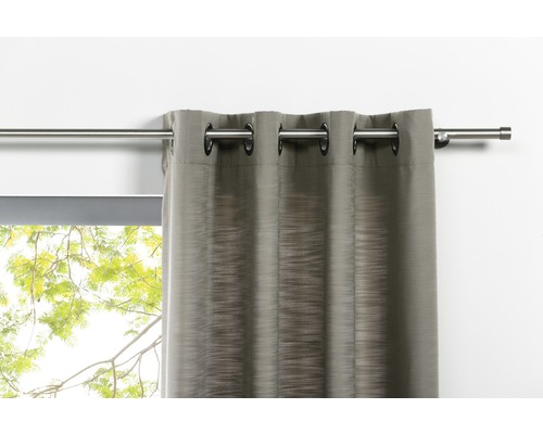 Rideau avec œillets sur tringle à rideaux devant la fenêtre