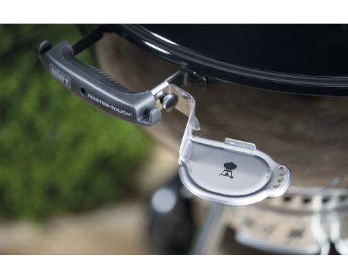 Vue détaillée d''un barbecue boule Weber avec support de couvercle et poignée