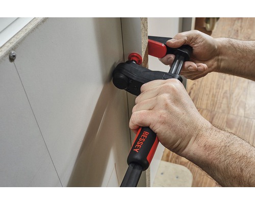 Eine Person verwendet eine Winkelklemme zur Befestigung eines Werkstücks.