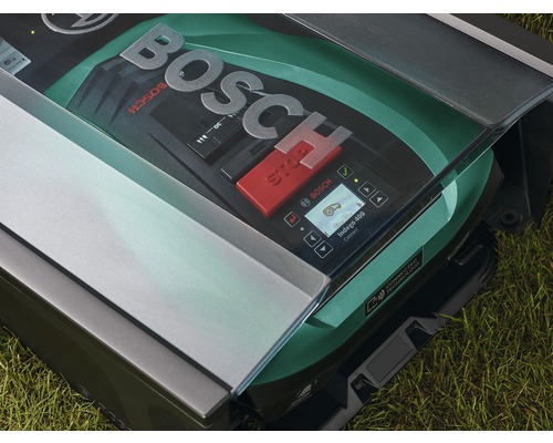 Robot tondeuse Bosch sur pelouse avec trappe ouverte