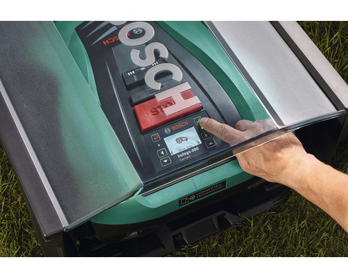 Logo Bosch sur un robot tondeuse avec une main appuyant sur un bouton
