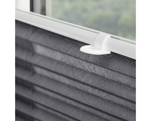 Detail einer grauen Plissee-Jalousie mit weisser Halterung am Fenster