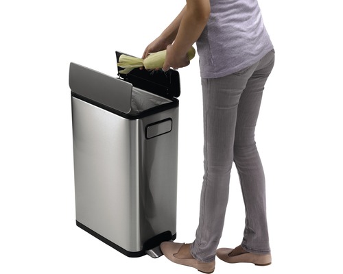 Femme jetant du maïs dans une poubelle à pédale en acier inoxydable