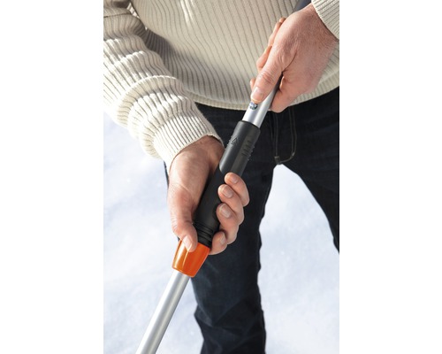 Personne tenant un chasse-neige avec manche télescopique