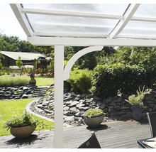 Detailansicht einer Terrassenüberdachung mit weißem Rahmen und transparentem Dach in einem Garten.