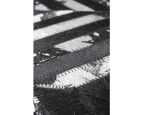 Detailansicht eines schwarz-weißen Teppichs mit Zickzackmuster aus Fell
