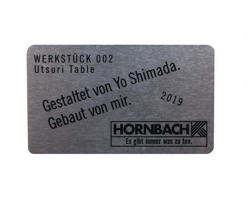 Plaque métallique avec l''inscription Pièce 002 Utsuri Table, conçue et construite par Yo Shimada, 2019, Logo Hornbach