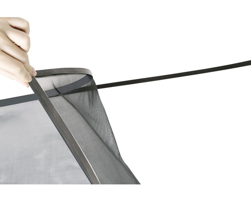 Gros plan d''une personne fixant une moustiquaire avec joint.