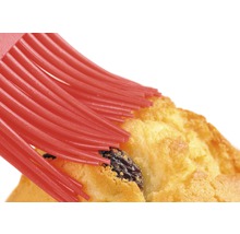 Une pâtisserie est badigeonnée à l''aide d''un pinceau.