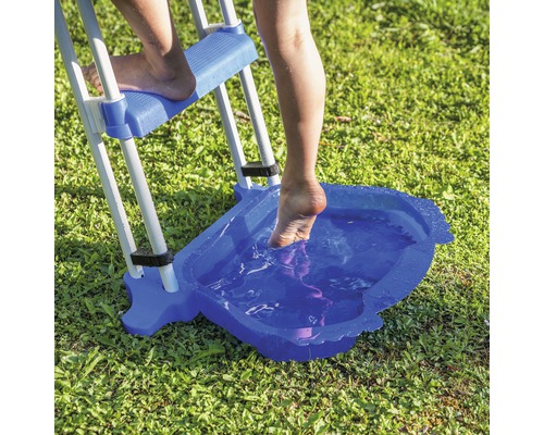 Person benutzt eine Poolleiter mit Fußbadewanne auf einer Rasenfläche