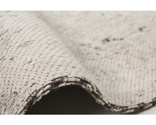 Detailansicht eines beigen Teppichs mit Textilmuster