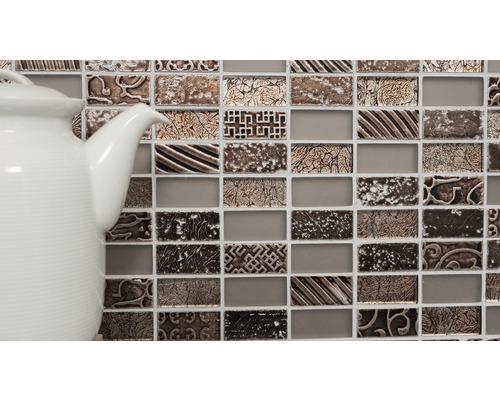 Mosaikfliesen mit Ornamenten und eine weiße Teekanne