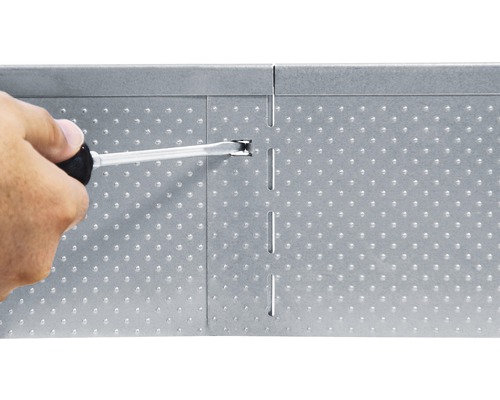 Person befestigt Lochblech mit Schraubenzieher.