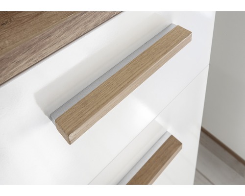 Detailaufnahme eines weißen Möbelstücks mit Holzgriffen