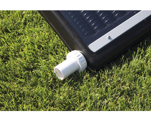 Vue détaillée d''un absorbeur solaire de piscine avec raccord de tuyau sur une pelouse