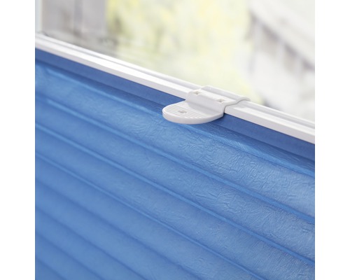 Nahaufnahme einer blauen Faltjalousie mit weißer Halterung am Fenster