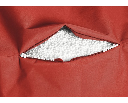 Gros plan d''un pouf rouge avec une fermeture éclair ouverte et un rembourrage en billes de polystyrène blanches