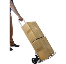 Une personne transporte deux cartons avec un diable.