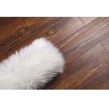 Tapis blanc sur plancher en bois