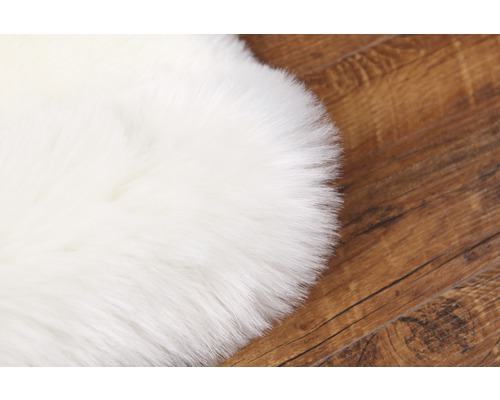 Weißer Teppich aus Kunstfell auf Holzboden