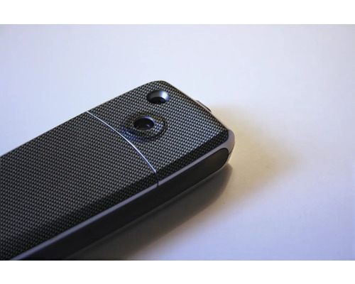 Vue détaillée d''un appareil électronique avec motif en fibre de carbone et deux évidements.