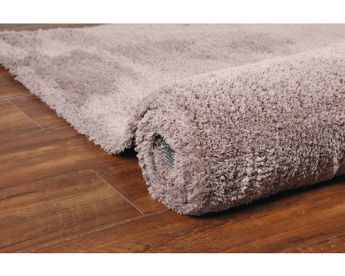 Gerollter Hochflor Teppich auf Holzboden