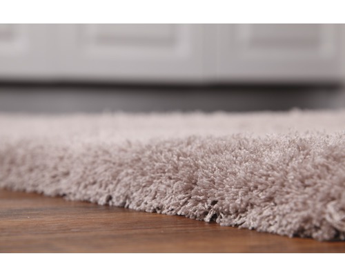 Nahaufnahme eines hochflorigen Teppichs auf einem Holzboden