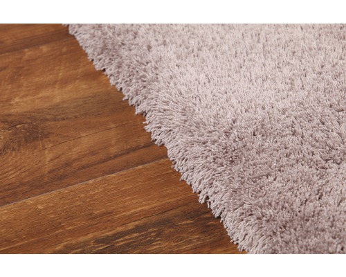 Detailansicht eines Teppichs mit hohem Flor auf einem Holzboden