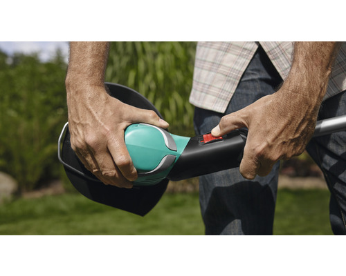 Eine Person bedient einen Rasentrimmer