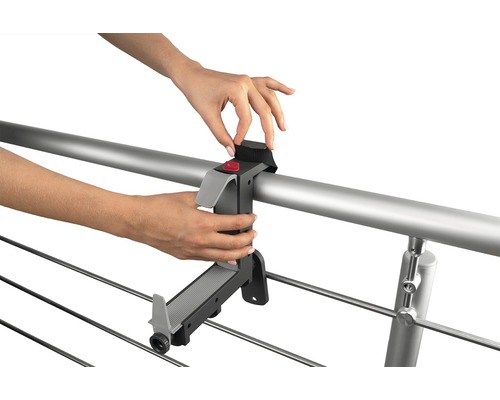 Person befestigt Wäscheständerhalterung an einem Geländer