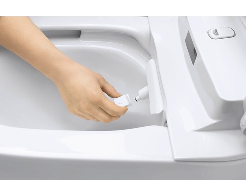 Une personne change la buse d''un WC douche.