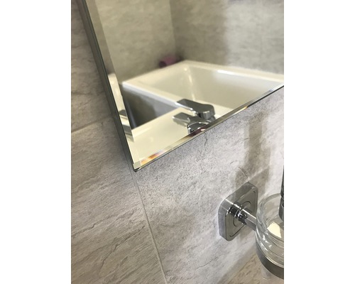Gros plan d'un miroir de salle de bains avec lavabo et robinet