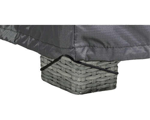 Gros plan d''une housse de protection grise sur une table en rotin avec cordon de serrage.