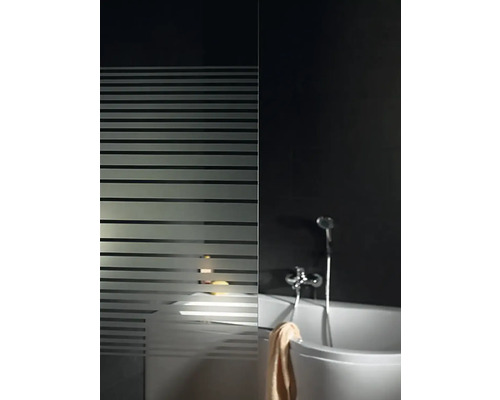 Salle de bains avec baignoire, robinetterie de douche et paroi de douche à rayures