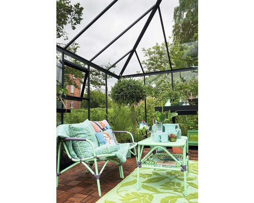 Idée d''aménagement pour une serre avec coin salon, table et décoration