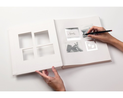 Album photo ouvert à personnaliser avec un stylo à la main