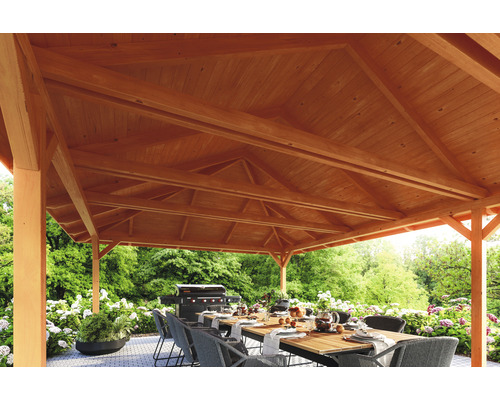 Detailansicht eines Holzpavillons mit Esstisch und Grill im Garten